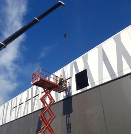 Crane and cheery picker working on the Tuggerah Homemakers Centre to remove and replace panels